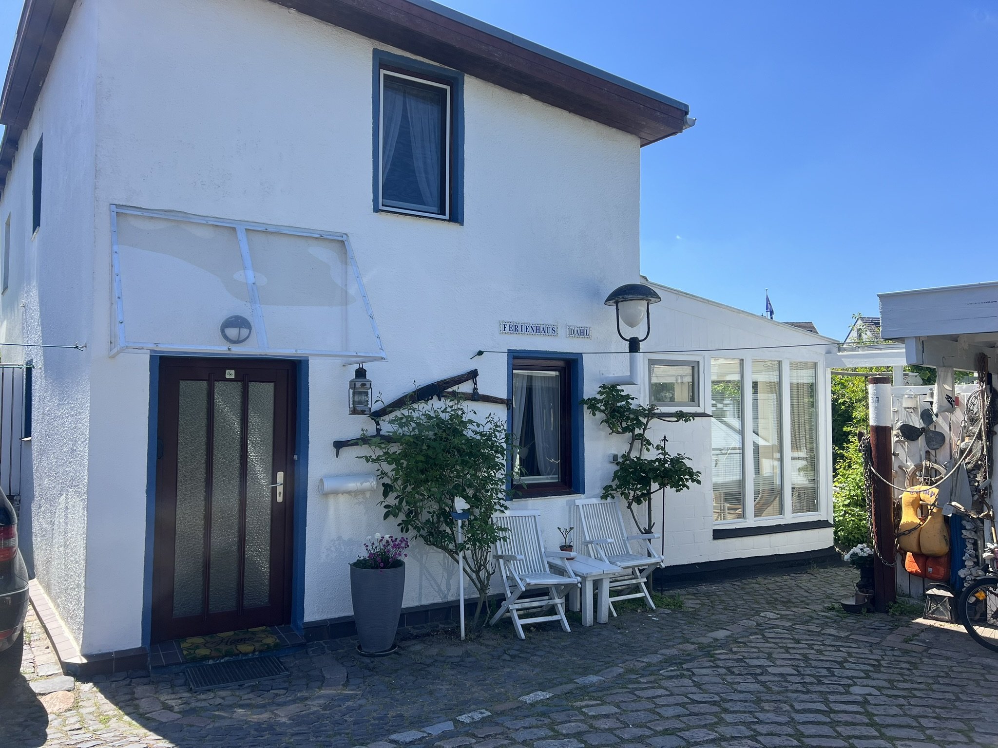 Frontansicht des Ferienhaus Dahl mit weißer Fassade und blauem Himmel