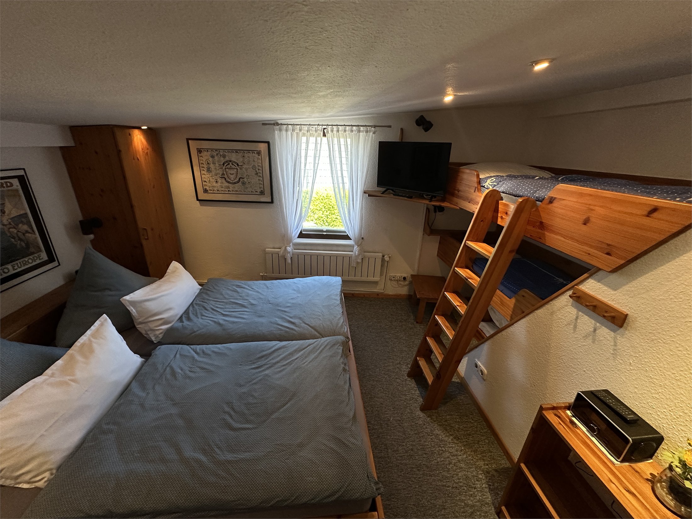 Schlafzimmer mit Doppelbett, Holzkojen und Fernseher